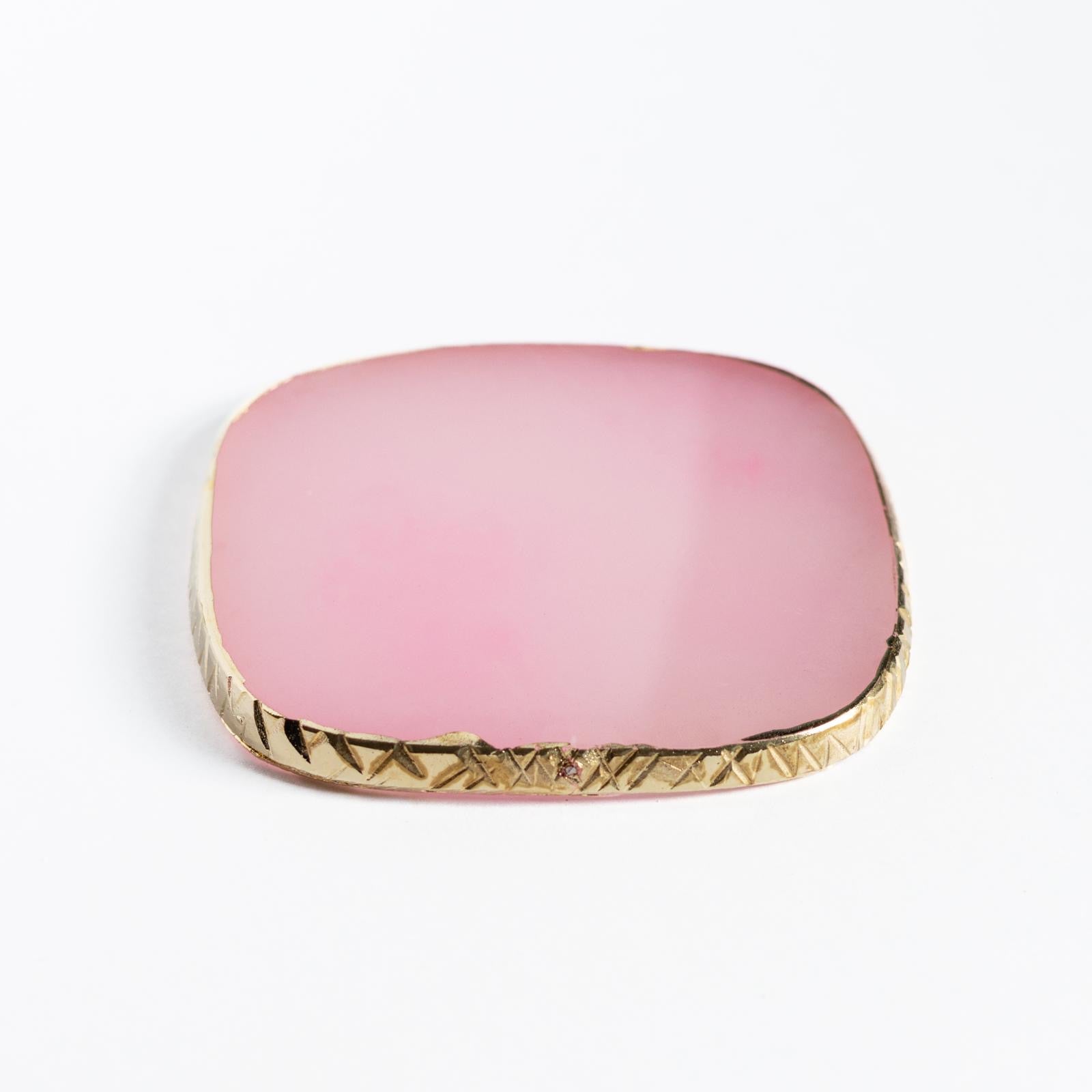 Pink square compact with gold trim on a white background